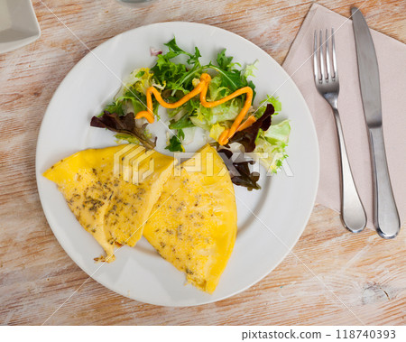 Fluffy omelet seasoned with herbs served with fresh greens Fluffy omelet seasoned with herbs served with fresh greens 118740393