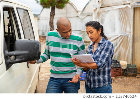Man and woman farmers talking near car 118740524