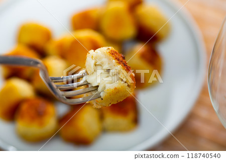 Cheese croquette with crunchy coating and creamy filling on fork Cheese croquette with crunchy coating and creamy filling on fork 118740540