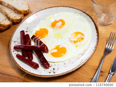 Fried eggs served with chistorra sausages 118740600