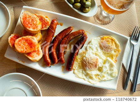 Fried eggs served with chistorra sausages 118740672
