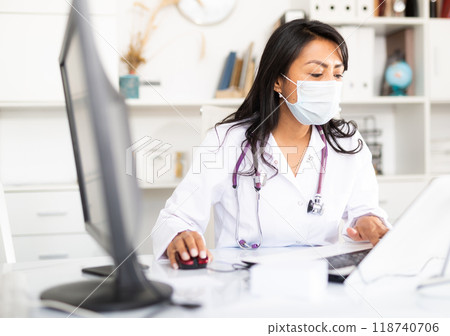 Latin american female doctor in face mask in office during COVID-19 118740706