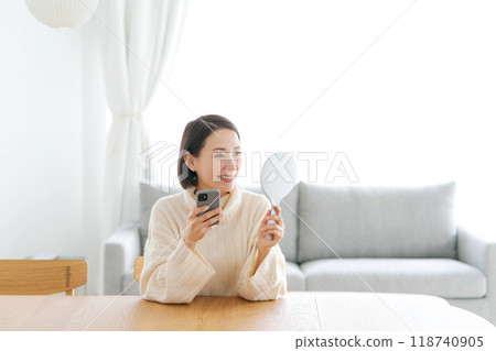 Middle-aged woman looking in the mirror and worried about skin problems 118740905