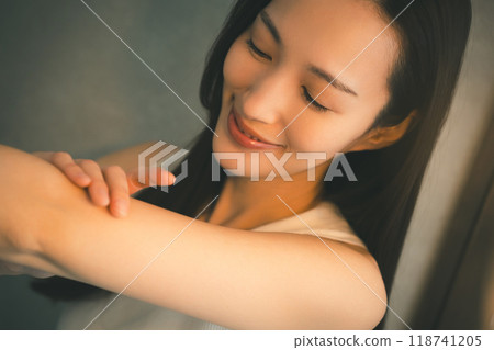Young woman's upper arm skin care at night Young woman's upper arm skin care at night 118741205