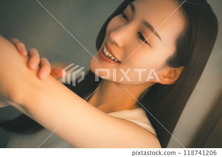 Young woman's upper arm skin care at night Young woman's upper arm skin care at night 118741206