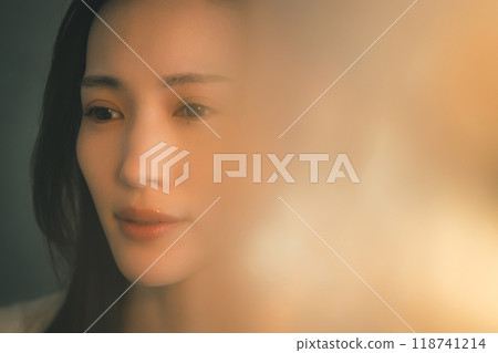 一個年輕女子孤獨地站在溫暖的燈光下 118741214