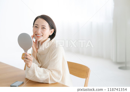 A woman in her 40s smiling in the mirror 118741354