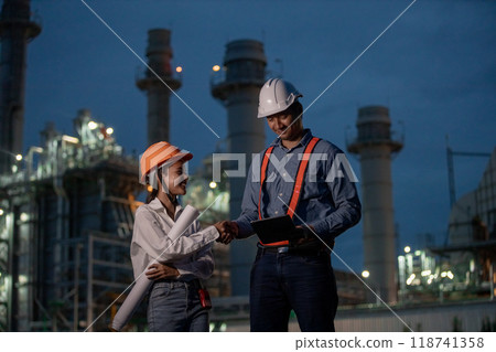 Asian team man and women engineer working at nighttime with blueprint Asian team man and women engineer working at nighttime with blueprint 118741358