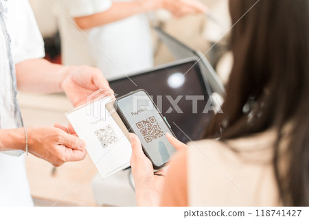女性顧客使用二維碼支付、智慧型手機支付、條碼支付、線上支付和智慧型手機電子支付 118741427