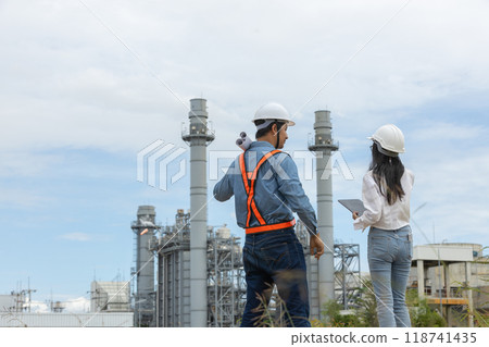Engineer with blueprint and tablet working factory producing electricity oil energy. 118741435