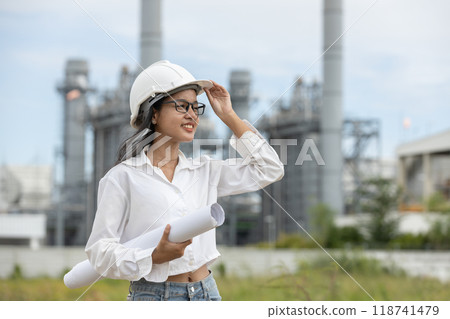 Engineer with blueprint working factory producing electricity oil energy. 118741479