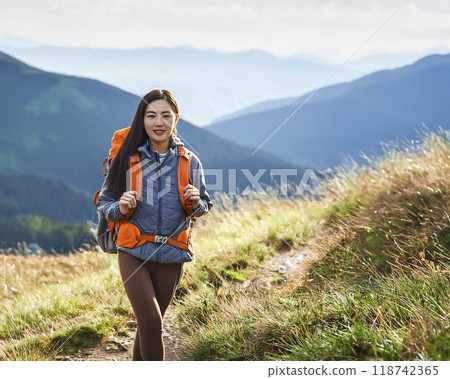 Image of a young woman enjoying trekking 118742365