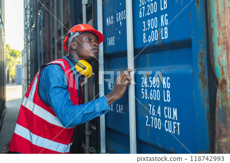 Male african american foreman opening door of container. 118742993