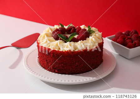 Red velvet cake on plate and berries in bowl on red background 118743126