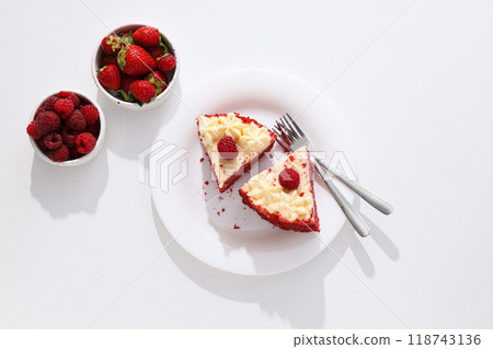 Pieces of red velvet cake on plate and berries on white background, top view Pieces of red velvet cake on plate and berries on white background, top view 118743136