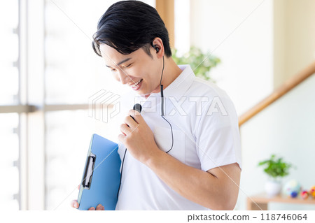Male caregiver working with a wireless microphone 118746064