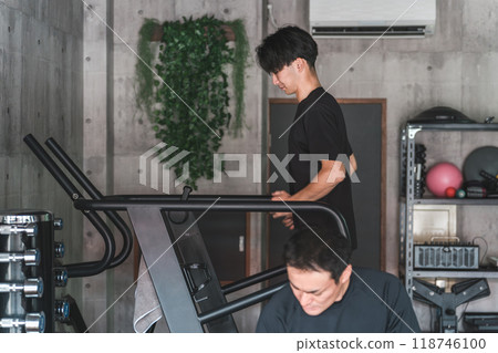 Asian man jogging and doing aerobic exercise using a treadmill/running machine at a sports gym 118746100