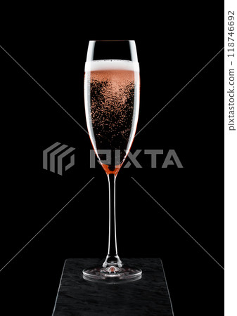 Elegant glass of pink rose champagne with bubbles on blavk marble board on black background. 118746692