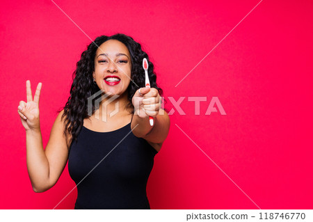 Pretty african lady with beautiful smile holding toothbrush and taking care of her teeth health Pretty african lady with beautiful smile holding toothbrush and taking care of her teeth health 118746770