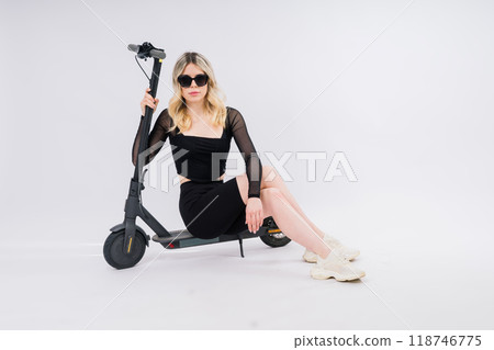 Woman ride e-scooter looking camera isolated on white background studio portrait. Lifestyle concept Woman ride e-scooter looking camera isolated on white background studio portrait. Lifestyle concept 118746775