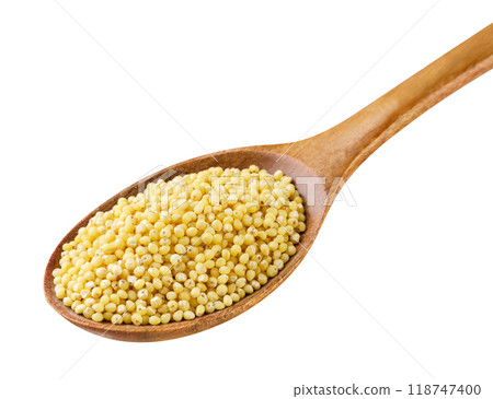 Millet groats in a wooden spoon close-up on a white. Isolated Millet groats in a wooden spoon close-up on a white. Isolated 118747400