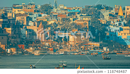 Varanasi, Uttar Pradesh, India. Boats Floating Near Rana Mahal Ghat, Darbhanga Ghat And Dashashwamedh Ghat In Early Morning. Many Hindu Temples. View From Riverbank Embankment Varanasi, Uttar Pradesh, India. Boats Floating Near Rana Mahal Ghat, Darbhanga Ghat And Dashashwamedh Ghat In Early Morning. Many Hindu Temples. View From Riverbank Embankment 118748487