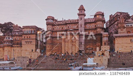 Varanasi, India. General View From Pleasure Boat On Sarvesvara And Digpatia Ghat. Purple Sunset Sky At Evening . Many Boats Moored On Ganga River. Camera Moving Along Riverbank Embankment Varanasi, India. General View From Pleasure Boat On Sarvesvara And Digpatia Ghat. Purple Sunset Sky At Evening . Many Boats Moored On Ganga River. Camera Moving Along Riverbank Embankment 118748489
