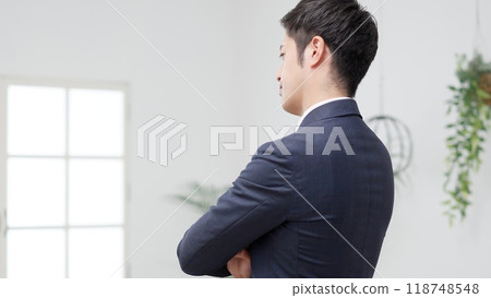 一位憂心忡忡的商人，雙臂交叉，面朝後 118748548