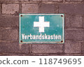 Green plate with a white cross and inscription - first aid kit 118749695