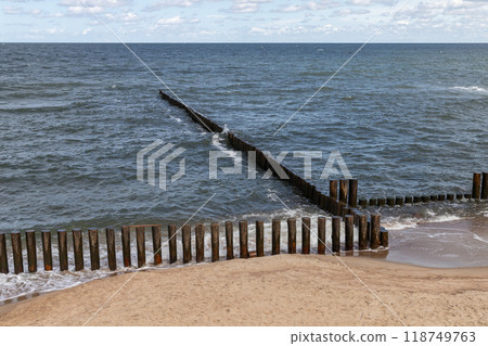 Seaside landscape with shore water and wooden breakwaters 118749763