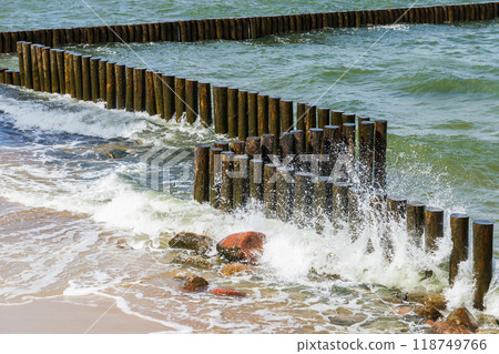 An old wooden breakwater structure and breaking waves at Baltic Sea 118749766