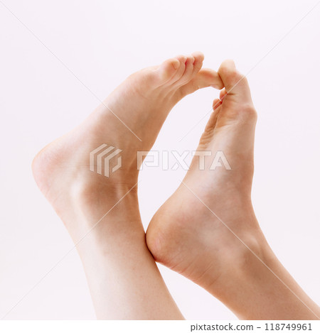 Cropped close-up image of female feet isolated on white studio background Cropped close-up image of female feet isolated on white studio background 118749961