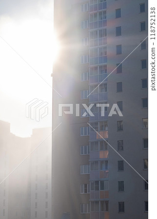 High rise apartment buildings with sunlight shining through the foggy atmosphere. High rise apartment buildings with sunlight shining through the foggy atmosphere. 118752138