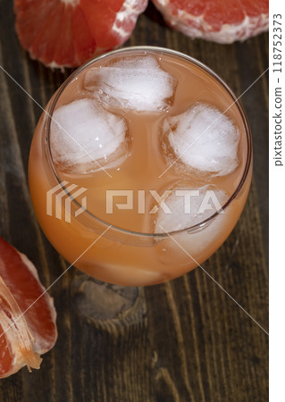 freshly squeezed juice in a glass and ripe red grapefruit on a black table freshly squeezed juice in a glass and ripe red grapefruit on a black table 118752373