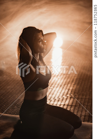 In a misty outdoor setting, a serene woman poses in stylish athletic wear, showcasing elegance and inspiring others with her graceful movements and dynamic energy, embodying strength and style In a misty outdoor setting, a serene woman poses in stylish athletic wear, showcasing elegance and inspiring others with her graceful movements and dynamic energy, embodying strength and style 118752865