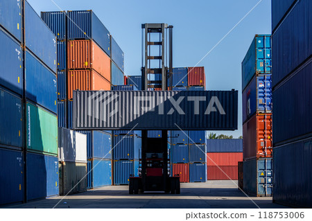 Forklift truck lifting container stack at containers yard Forklift truck lifting container stack at containers yard 118753006