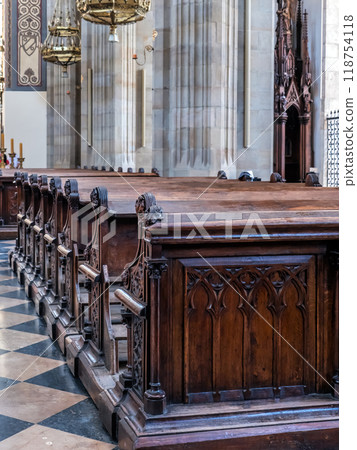 Church aisle with ornamental wooden pews 118754118