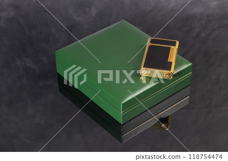 High quality lighter in a box on a dark background. Office interior. High quality lighter in a box on a dark background. Office interior. 118754474