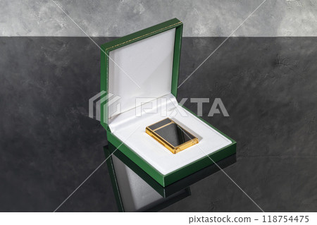 High quality lighter in a box on a dark background. Office interior. High quality lighter in a box on a dark background. Office interior. 118754475