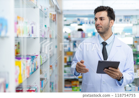 man pharmacists are selecting medications for patients online via tablet in drug store. man pharmacists are selecting medications for patients online via tablet in drug store. 118754755