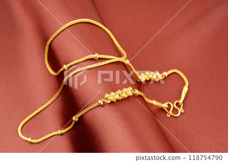 A Gold Necklace on red silk background. A Gold Necklace on red silk background. 118754790