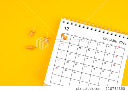 December 2024 Monthly desk calendar for 2024 year with wooden pin on yellow background. 118754860