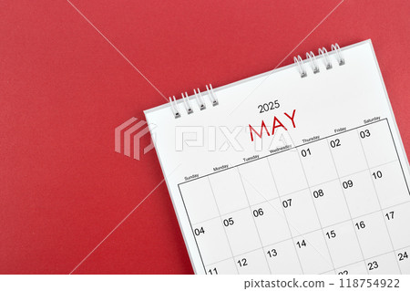 May 2025 desk calendar on red background. 118754922