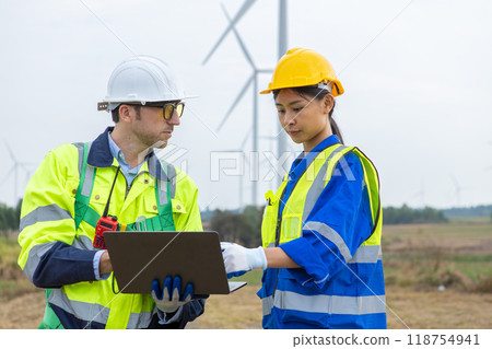 Team engineer of wind turbine worker pointing holding laptop working about renewable Team engineer of wind turbine worker pointing holding laptop working about renewable 118754941