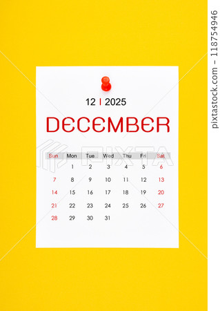 December 2025 calendar page with push pin on yellow color background. 118754946