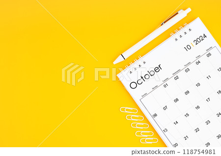 October 2024, Monthly desk calendar for 2024 year and pen with paper clips on yellow color background. 118754981