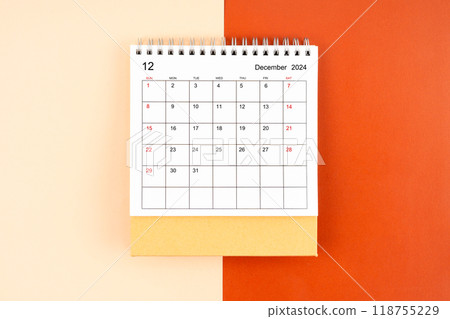 Directly above view of December 2024 desk calendar on orange background. Directly above view of December 2024 desk calendar on orange background. 118755229