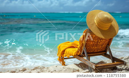 Relaxing Beach Chair With a Sun Hat and Yellow Towel by the Clear Blue Ocean on a Sunny Day 118755380