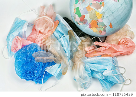 used gloves, medical masks and shoe covers on a globe background. The problem of ecology used gloves, medical masks and shoe covers on a globe background. The problem of ecology 118755459