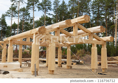 The construction site of a wooden house. Traditional log cabin built from wood logs. Cottage house design The construction site of a wooden house. Traditional log cabin built from wood logs. Cottage house design 118756712